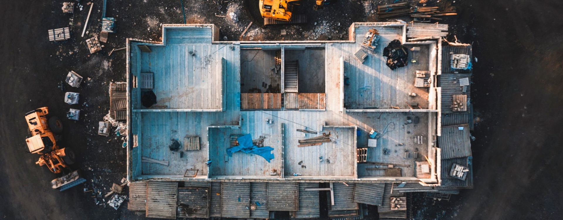 Aerial birds eye image of the frame of a house being built on a construction site at sunset - Wooden floor and walls are visible