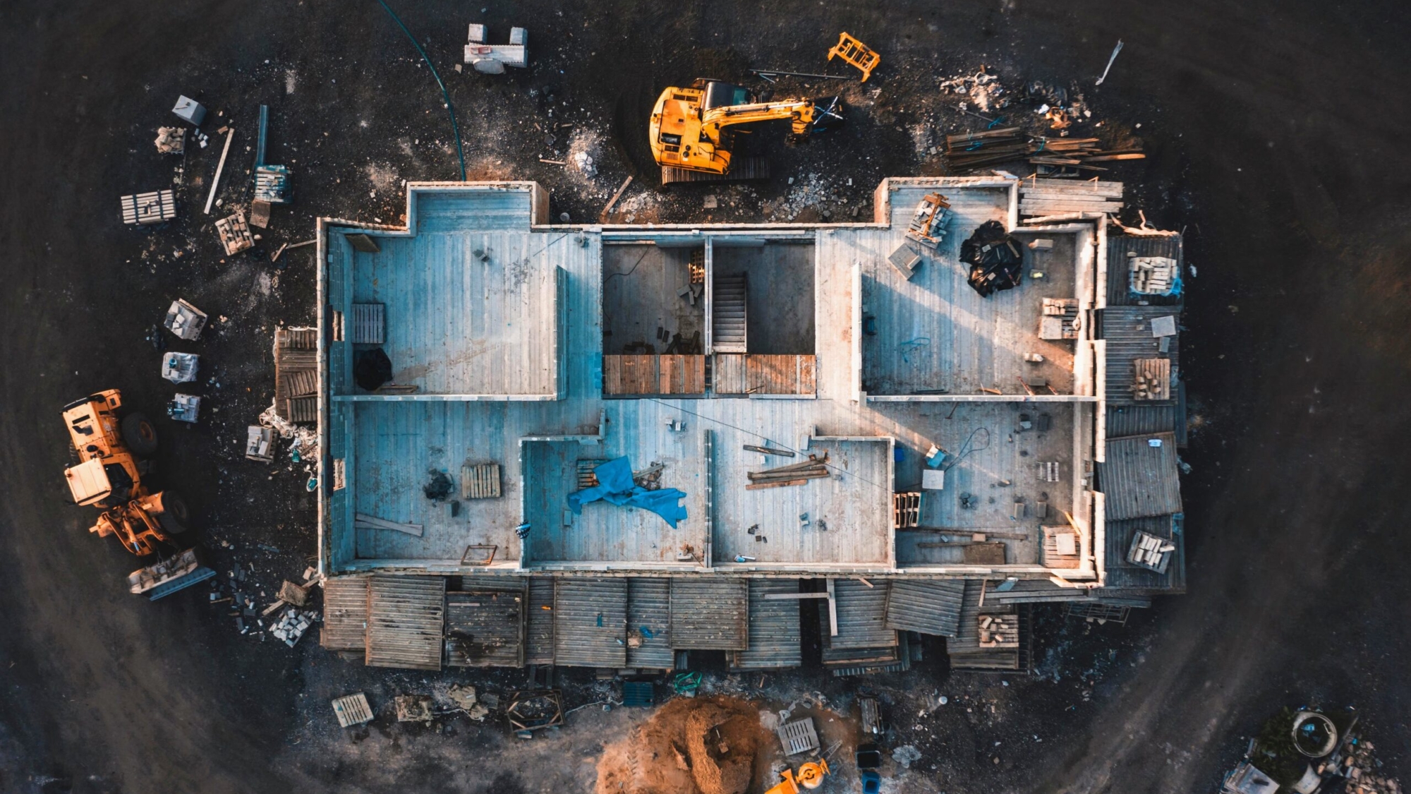 Aerial birds eye image of the frame of a house being built on a construction site at sunset - Wooden floor and walls are visible